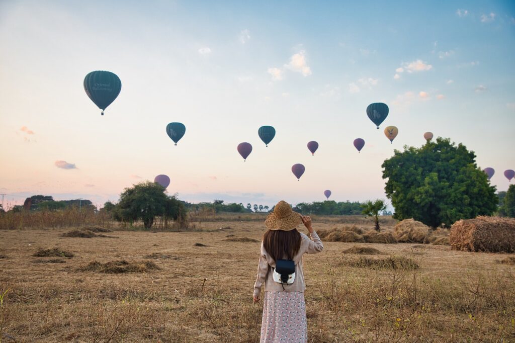 woman, field, hot air balloons